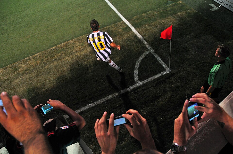 Jugador ejecutando un tiro de esquina en un estadio
